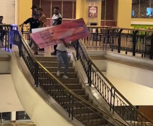Um f&atilde; da artista corre pelas escadarias de um shopping em Guadalajara, no M&eacute;xico, levando a arte do filme