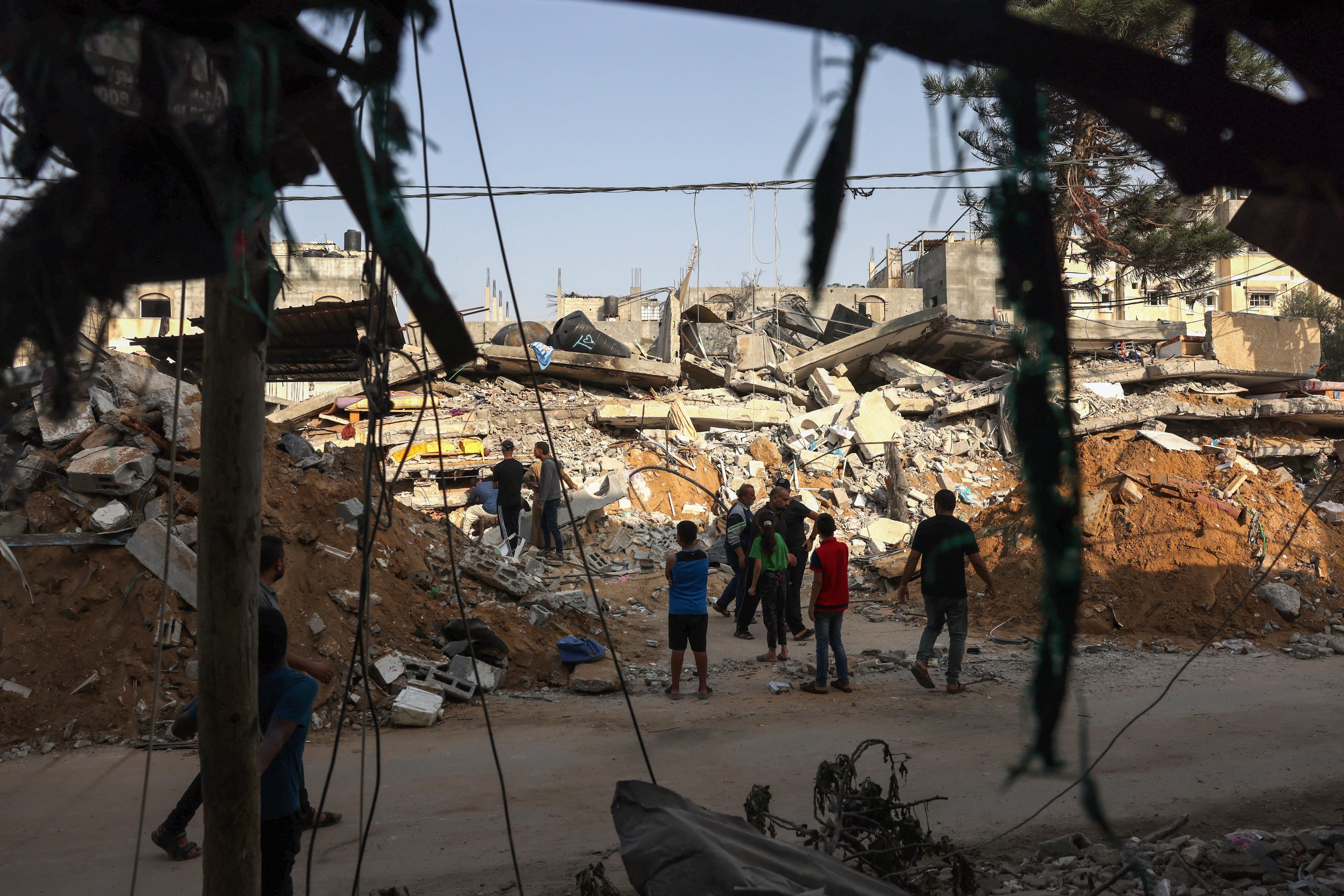 Palestinos procuram por sobreviventes entre os escombros de edif&iacute;cio em Rafah, no sul de Gaza