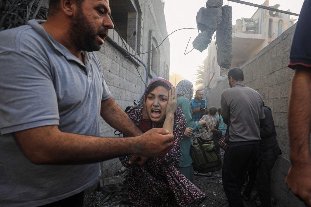 Pessoas fogindo de ataques a&eacute;reos israelenses contra um bairro do campo de refugiados de al-Maghazi, no centro da Faixa de Gaza