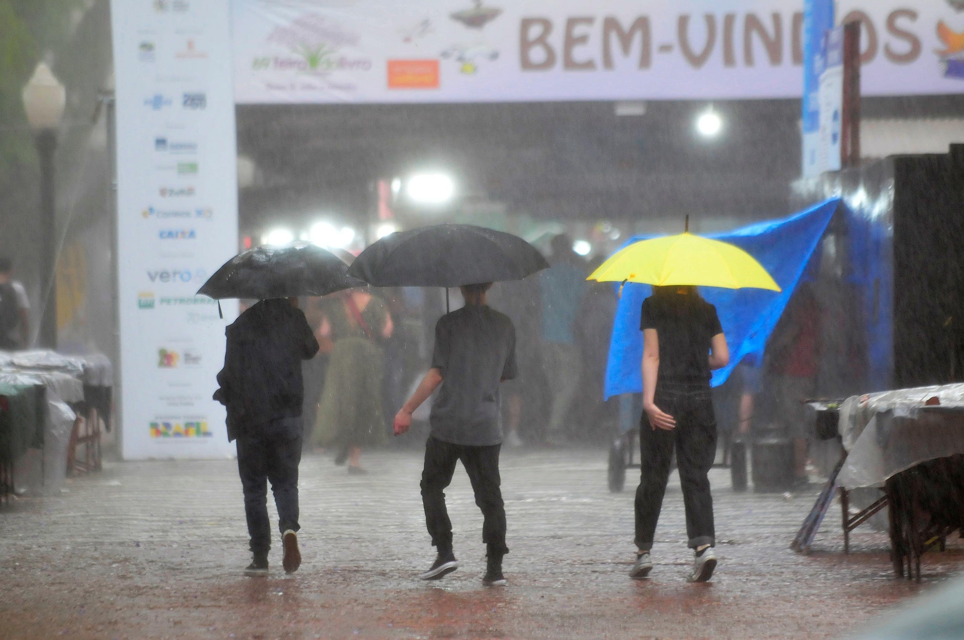 Chuva chegou de surpresa no Centro Hist&oacute;rico de Porto Alegre e levou pessoas &agrave; se abrigarem em guarda-chuvas e nas lonas da Feira do Livro