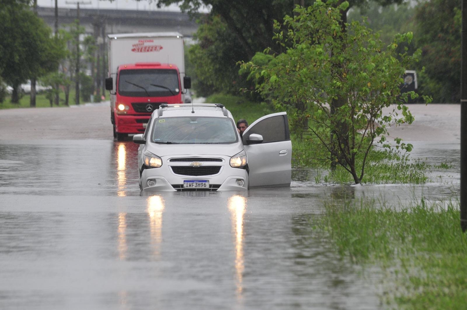 Motorista precisou empurrar ve&iacute;culo que ficou submerso em &aacute;rea de alagamento na rua Volunt&aacute;rios da P&aacute;tria