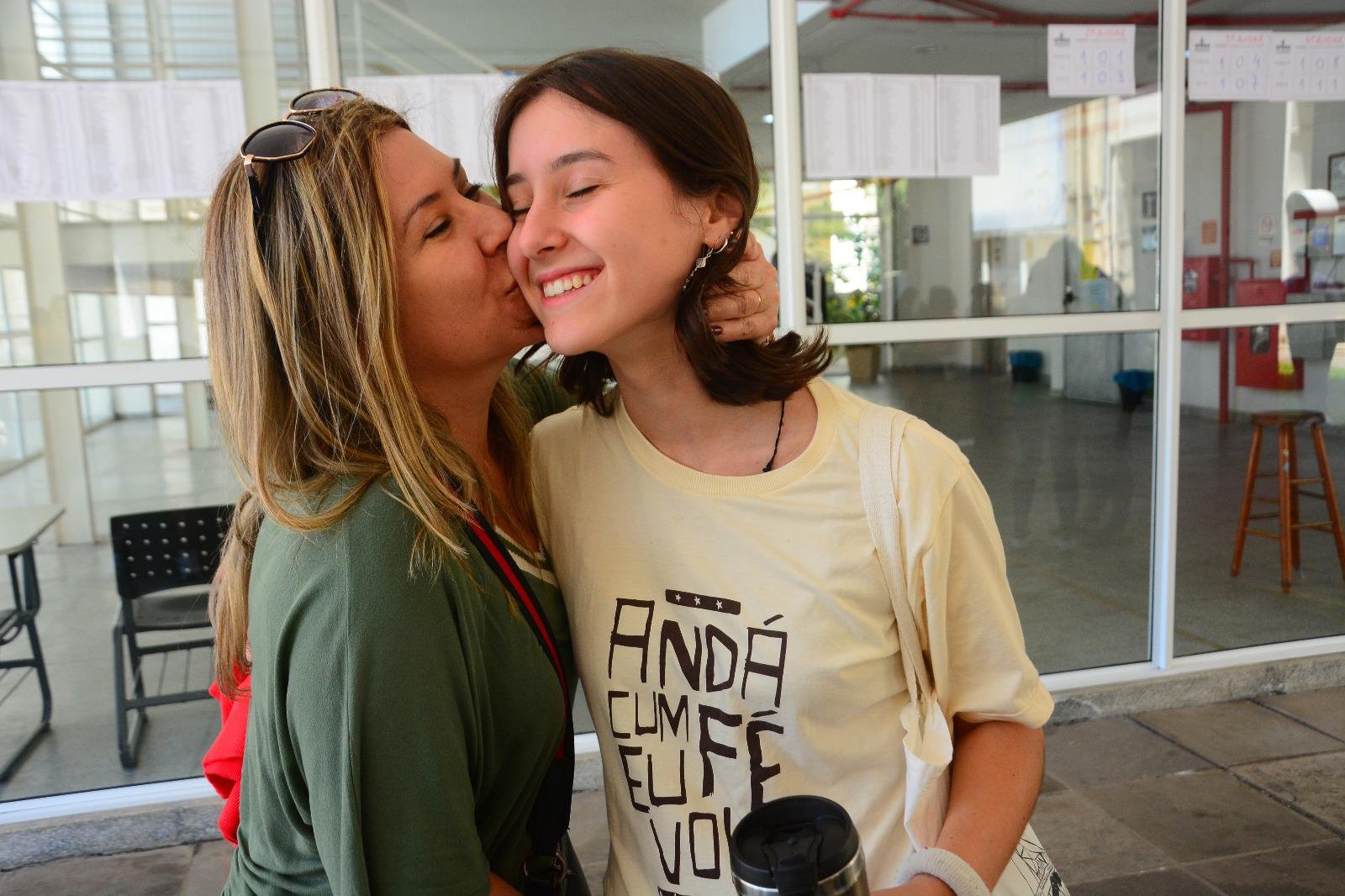 Helena recebe um beijo de boa sorte da m&atilde;e, Cintia Santos, antes de ingressar no pr&eacute;dio