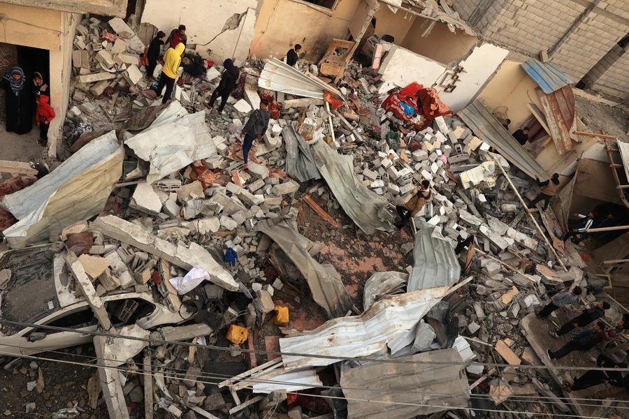 Palestinos inspecionam uma casa destru&iacute;da ap&oacute;s ataques a&eacute;reos israelenses em Rafah, no sul da Faixa de Gaza