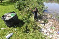 Reciclador recolhe garrafas plásticas e outros materiais que se  acumulam às margens do Guaíba.