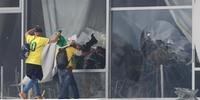 Apoiadores do ex-presidente Jair Bolsonaro invadem o Congresso Nacional por janela quebrada, em Brasília.