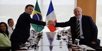 O presidente da França, Emmanuel Macron (E) e o presidente do Brasil, Luiz Inácio Lula da Silva (R), apertam as mãos durante reunião bilateral no Palácio do Planalto, em Brasília, em 28 de março de 2024.