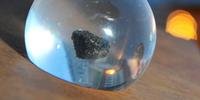 Acomodada em uma pequena esfera de acrílico, pedra de aparência esponjosa pesa 1,1 grama e mede pouco menos de um centímetro