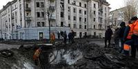 Funcionários dos serviços municipais ucranianos examinam e reparam os danos após um ataque com mísseis em Kiev