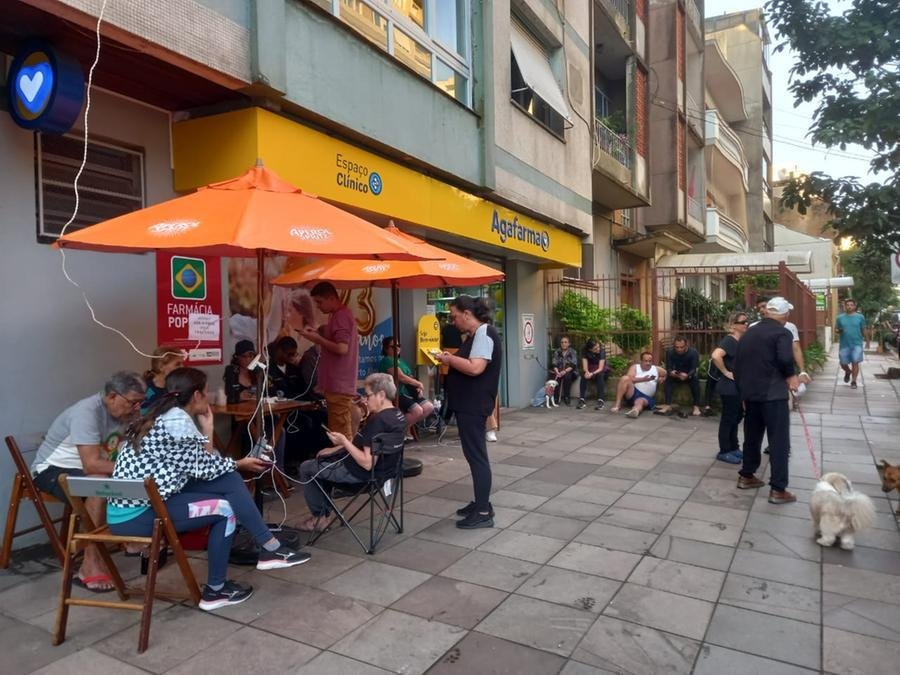 Farm&aacute;cia na Duque de Caxias colocou extens&otilde;es na cal&ccedil;ada para moradores carregarem celulares