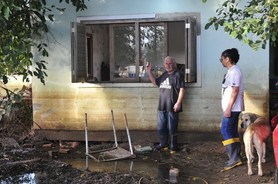 Moradores aproveitam o recuo da &aacute;gua para fazer a limpeza