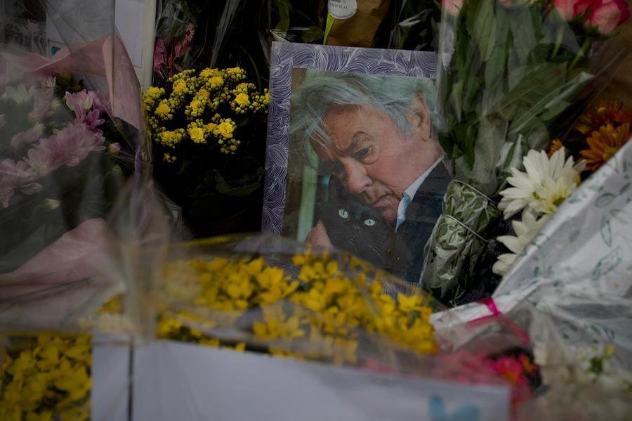 Retrato do falecido ator franc&ecirc;s Alain Delon em meio a flores deixadas por seus f&atilde;s no port&atilde;o de entrada da propriedade de Delon, La Brulerie, em Douchy, centro da Fran&ccedil;a