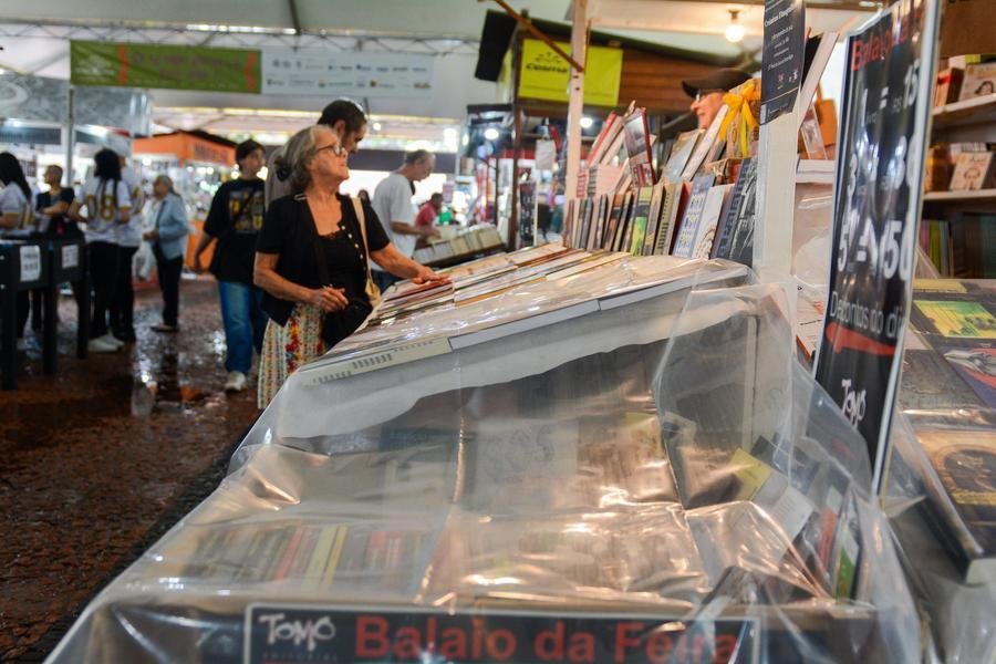 Alguns livreiros colocaram pl&aacute;stico sobre os livros para proteg&ecirc;-los da chuva no in&iacute;cio da tarde