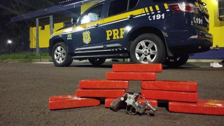 Tabletes com a droga e a arma estavam no painel de um ve&iacute;culo Fiat Palio
