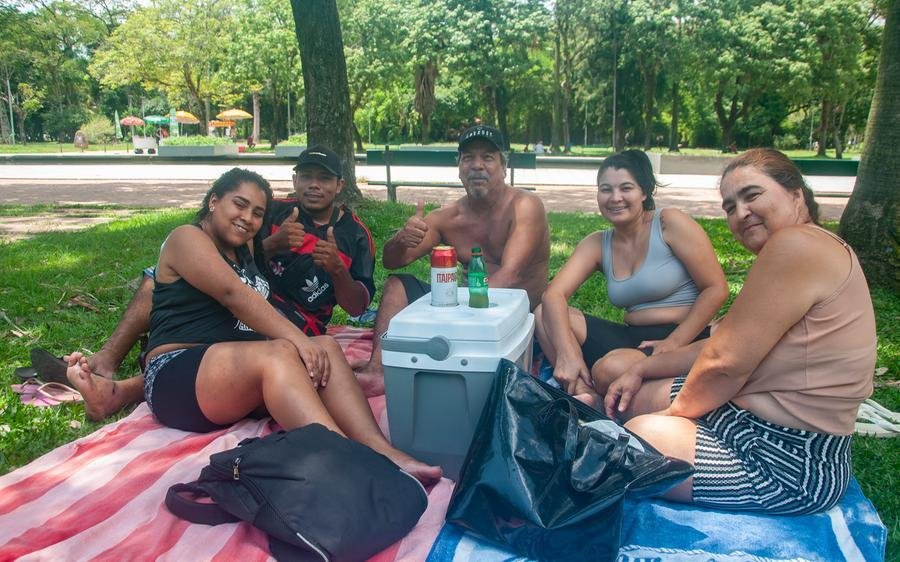 O chapeador S&iacute;lvio Luiz Oliveira e sua fam&iacute;lia amenizam o calor na sombra das &aacute;rvores