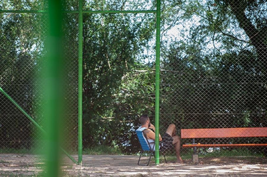 Na orla do bairro Guaruj&aacute;, morador buscou na sombra da &aacute;rvore, na beira do Gua&iacute;ba, um ref&uacute;gio para ler e fugir do forte calor