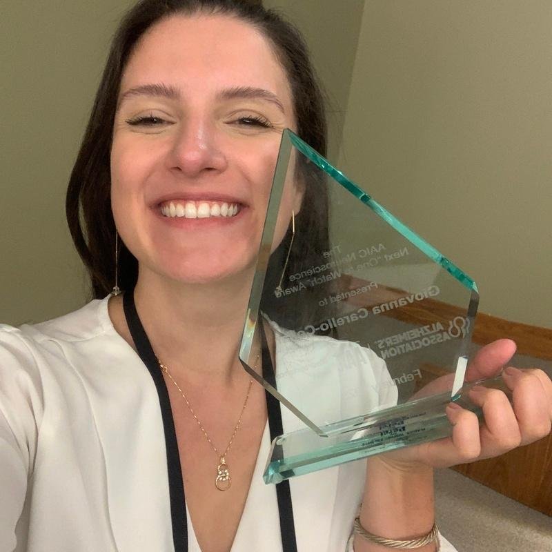 Giovanna Collar com o trof&eacute;u que representa pr&ecirc;mio AAIC Neuroscience Next "One to watch"