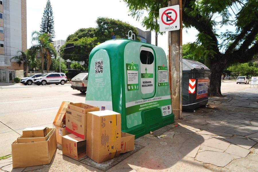 Caixas ao lado de cont&ecirc;iner de coleta seletiva