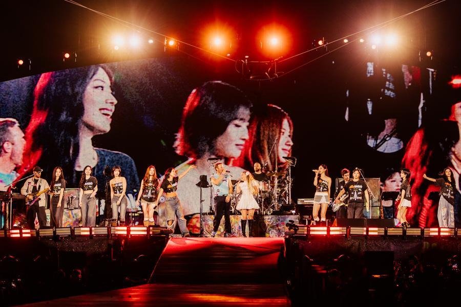 Grupo Twice no palco com o Coldplay em Seul