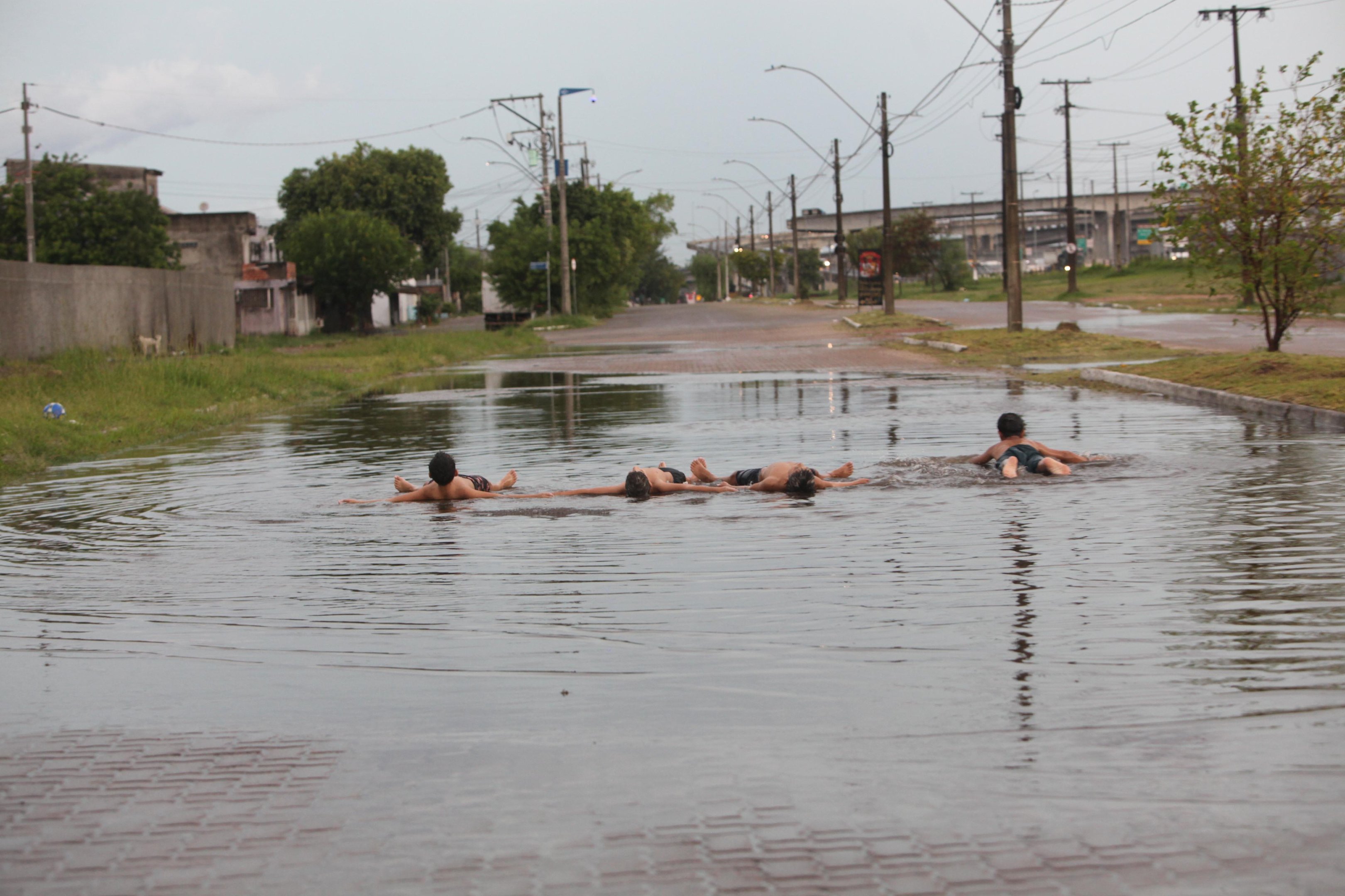 Na zona Norte, meninos aproveitaram a "piscina" formada na Volunt&aacute;rios da P&aacute;tria para se refrescar