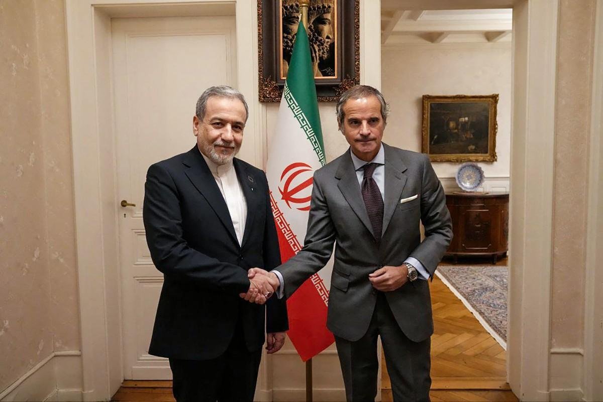 O Ministro das Rela&ccedil;&otilde;es Exteriores iraniano, Abbas Araghchi (&agrave; esquerda), cumprimenta o chefe da Ag&ecirc;ncia Internacional de Energia At&ocirc;mica, Rafael Grossi, durante uma reuni&atilde;o em Genebra