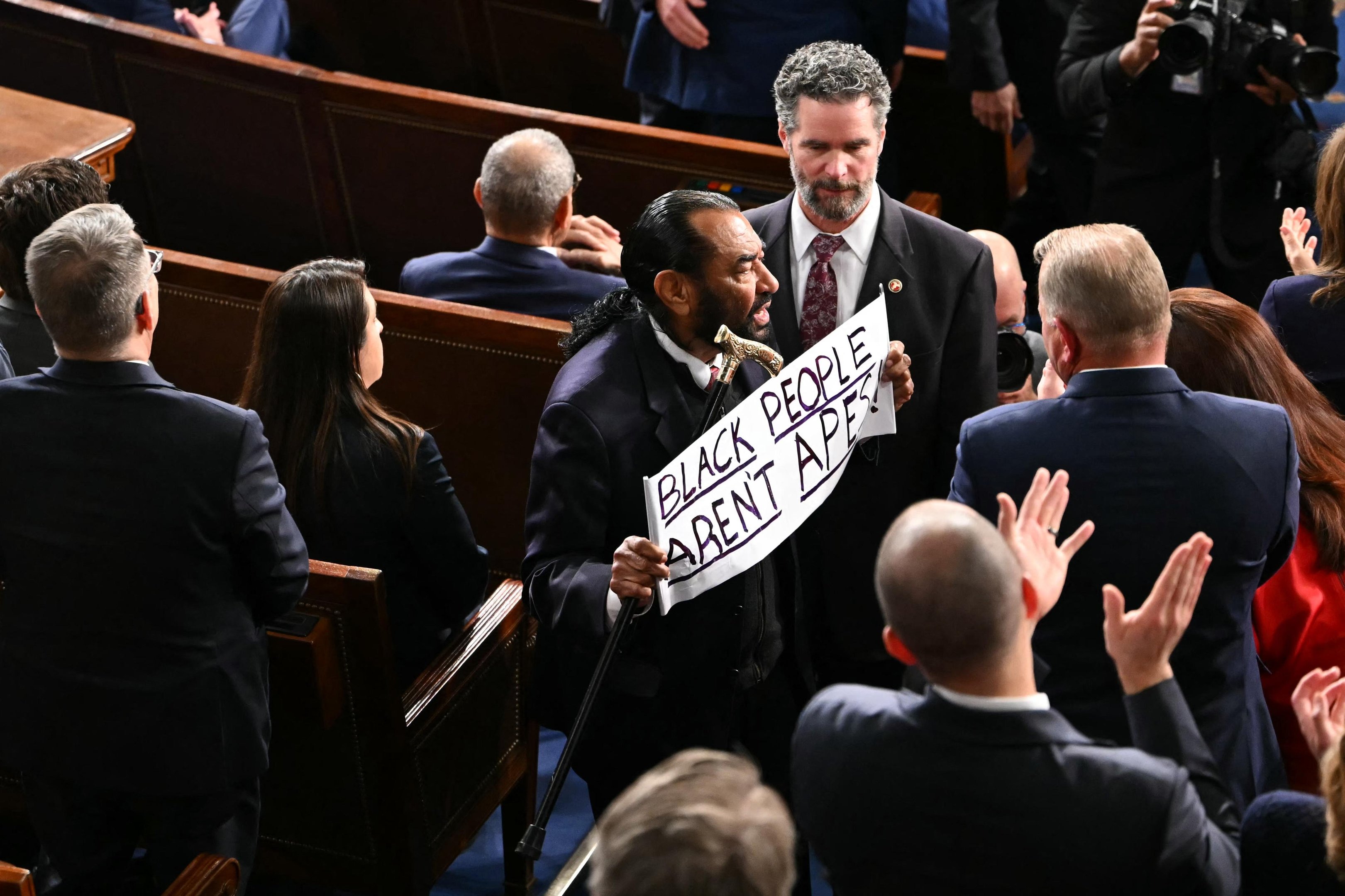 Congressista Al Green, do estado do Texas, ficou de p&eacute; quando Trump chegou para fazer seu discurso na sess&atilde;o conjunta do Congresso, e exibiu o cartaz