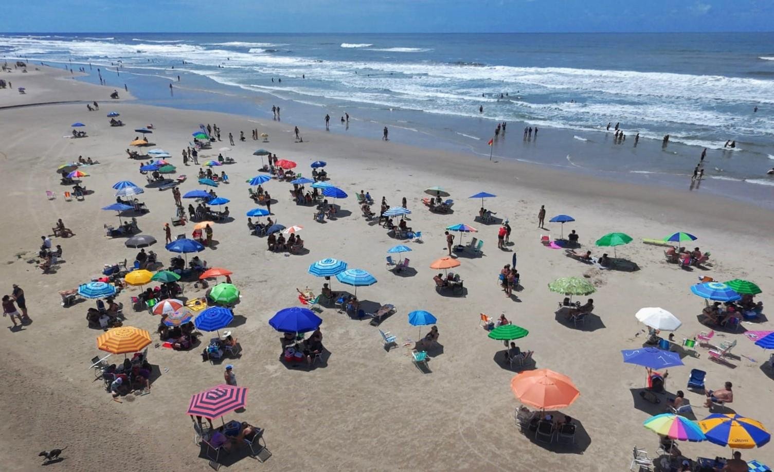 Muitas fam&iacute;lias foram para a beira da praia de Arroio do Sal aproveitar a manh&atilde; de forte calor e &aacute;gua cristalina