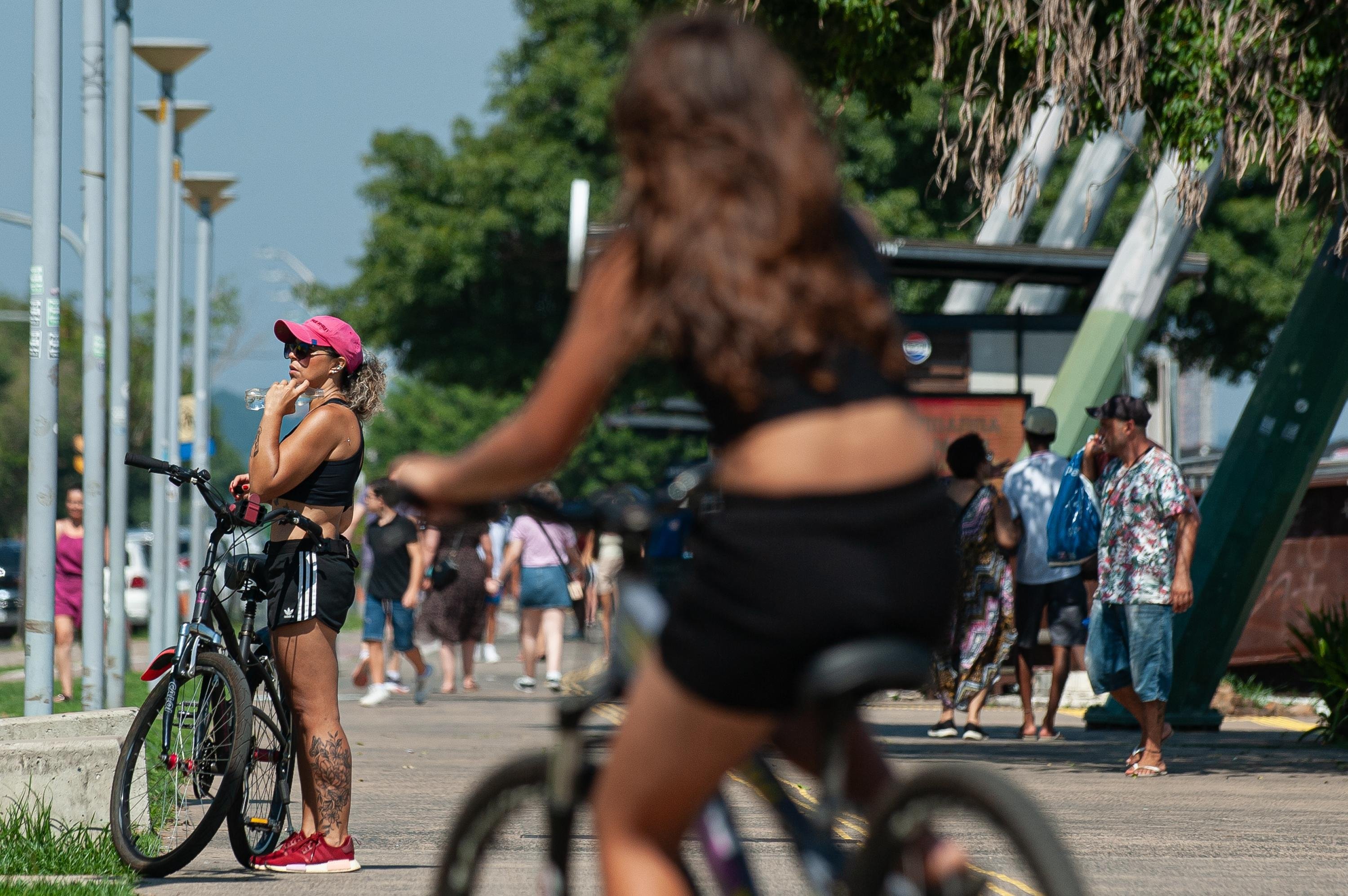 Pessoas buscam por sombras na Orla do Gua&iacute;ba sob sol forte e altas temperaturas