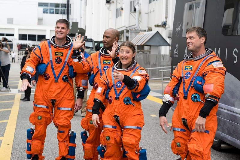 Os quatro astronautas da miss&atilde;o Artemis II, incluindo Christina Koch (no centro, apontando), acenam para a equipe ao deixarem o Neil Armstrong Operations and Checkout Building no Kennedy Space Center