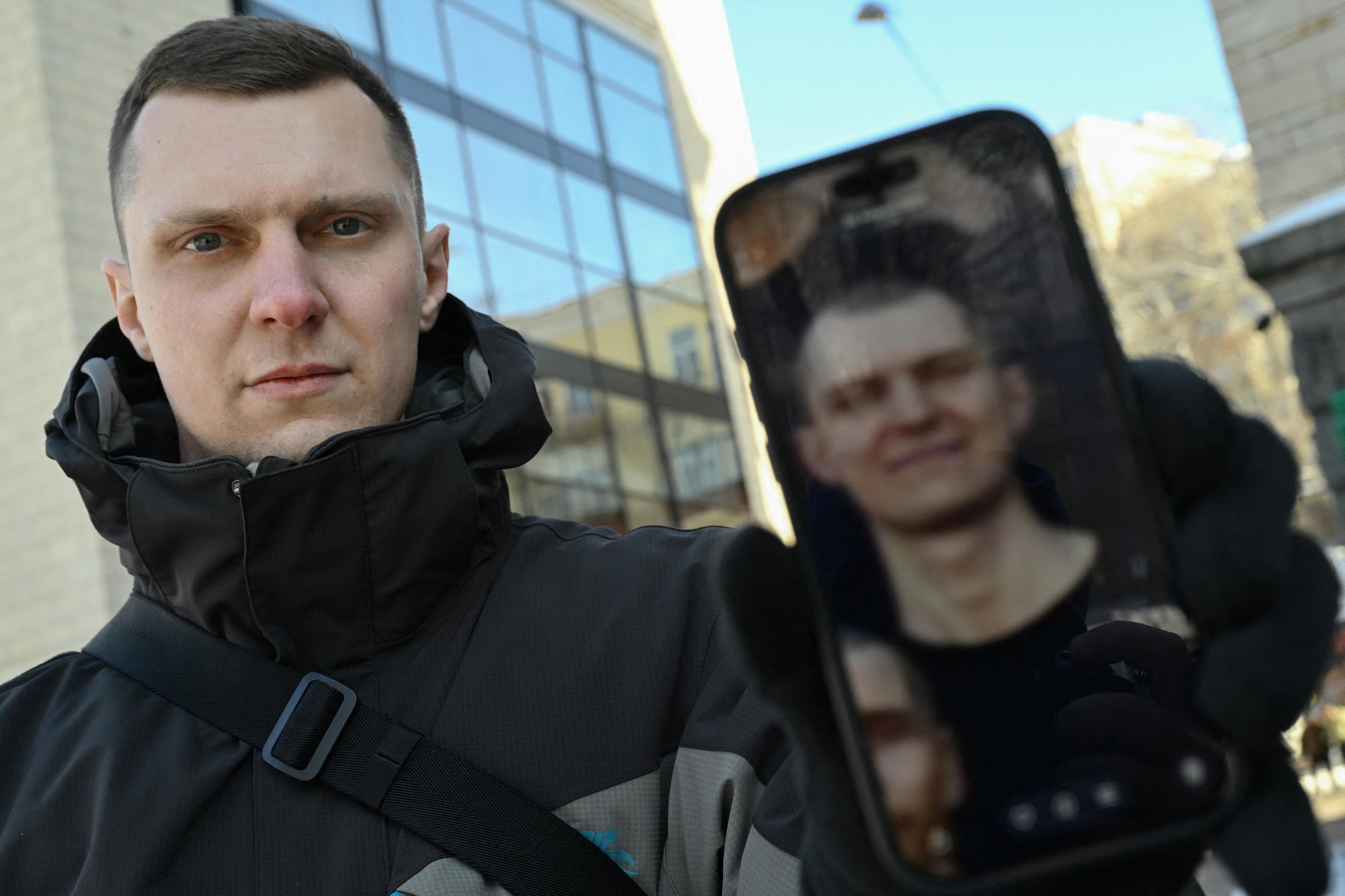 Yaroslav Rumyantsev mostra uma fotografia sua no cativeiro russo em um celular