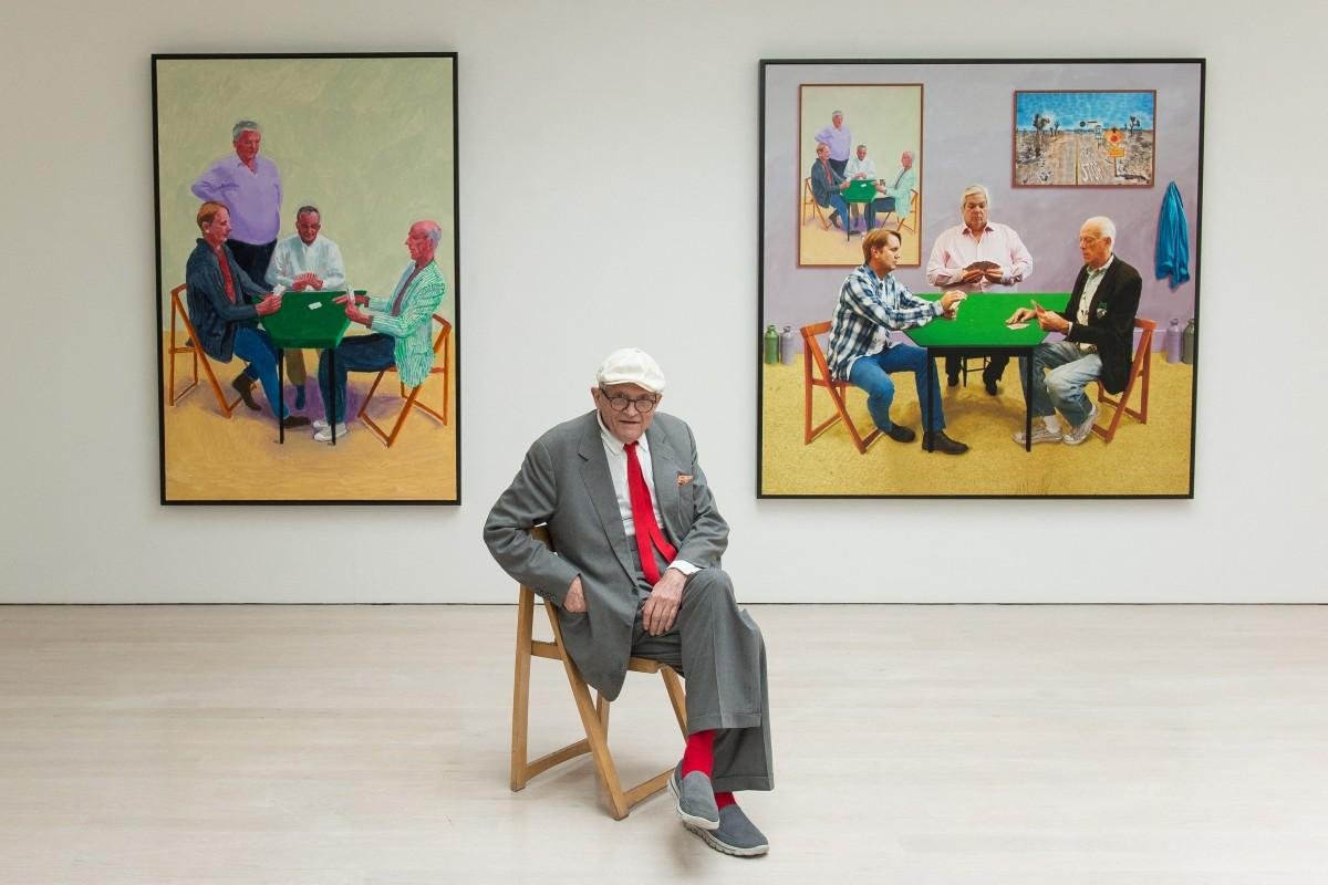 Artista David Hockney ao lado de duas de suas obras de arte