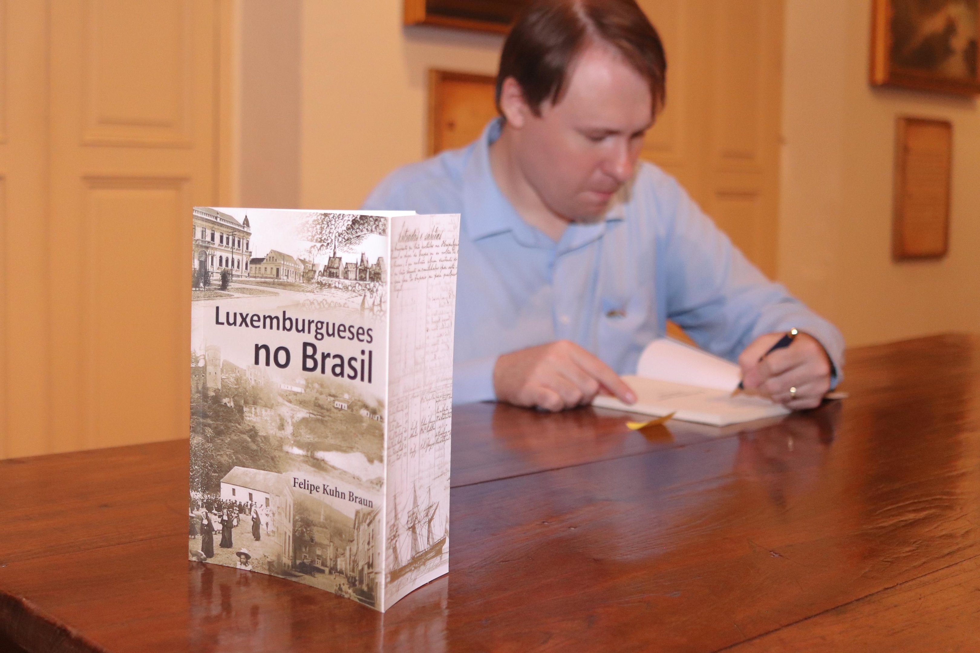 Felipe Kuhn Braun autografa livro sobre a imigra&ccedil;&atilde;o luxemburguesa em evento em Porto Alegre