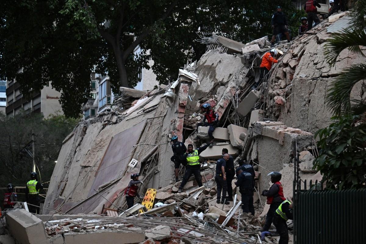 Equipes de resgate buscam v&iacute;timas em um pr&eacute;dio desabado ap&oacute;s terremoto