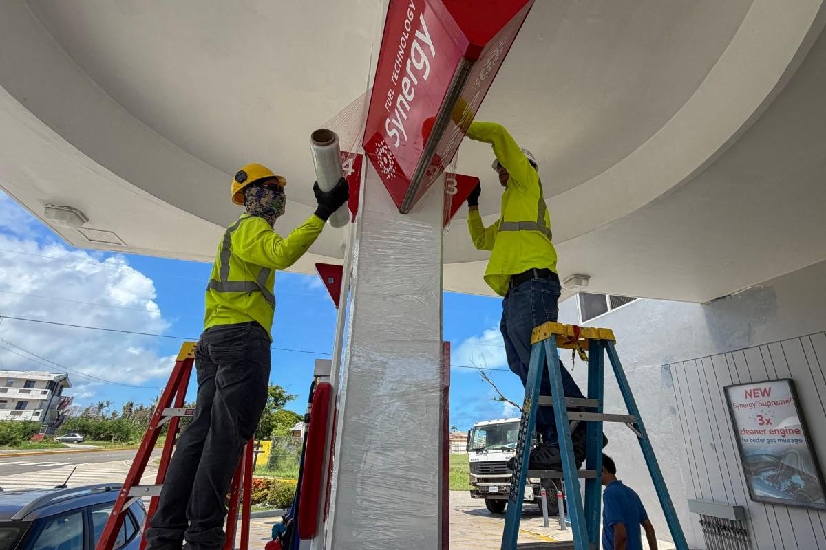 Trabalhadores refor&ccedil;am a seguran&ccedil;a de um posto de gasolina antes da chegada do supertuf&atilde;o Bavi
