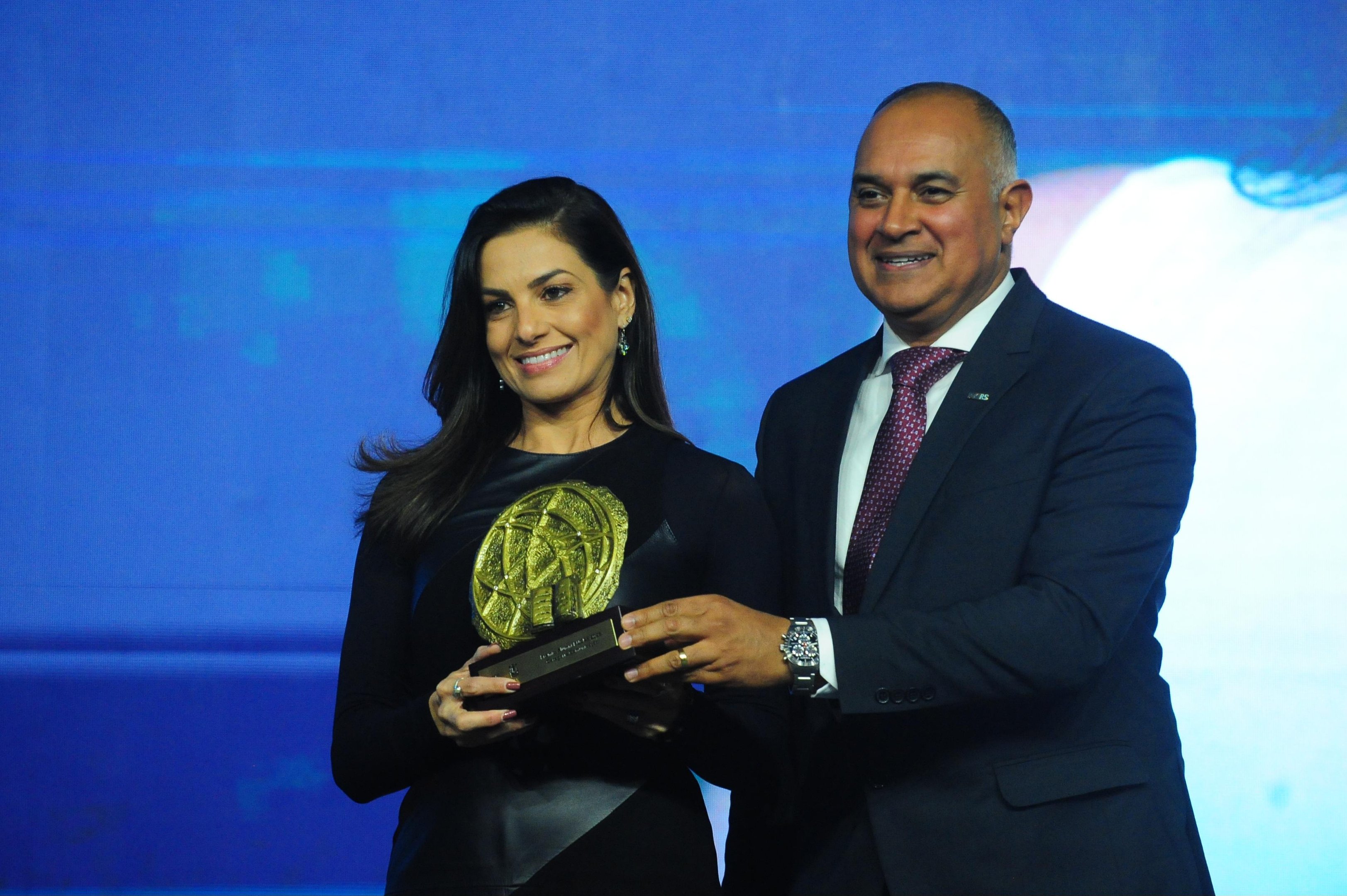 O trof&eacute;u foi entregue &agrave; homenageada pelo diretor de Rela&ccedil;&otilde;es Institucionais da PUCRS, Solimar Amaro