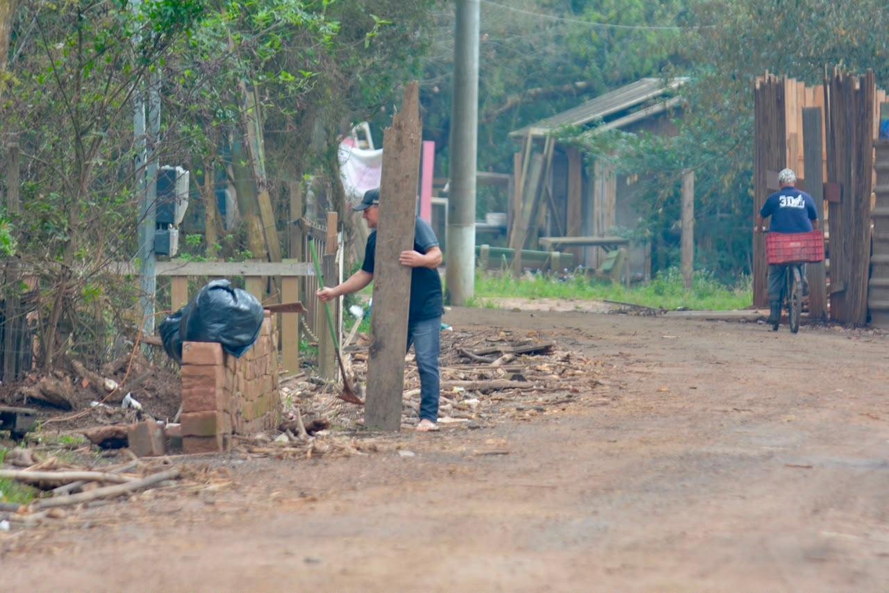 Moradores e o DMLU limpam dos detritos levados pelo rio durante a inunda&ccedil;&atilde;o