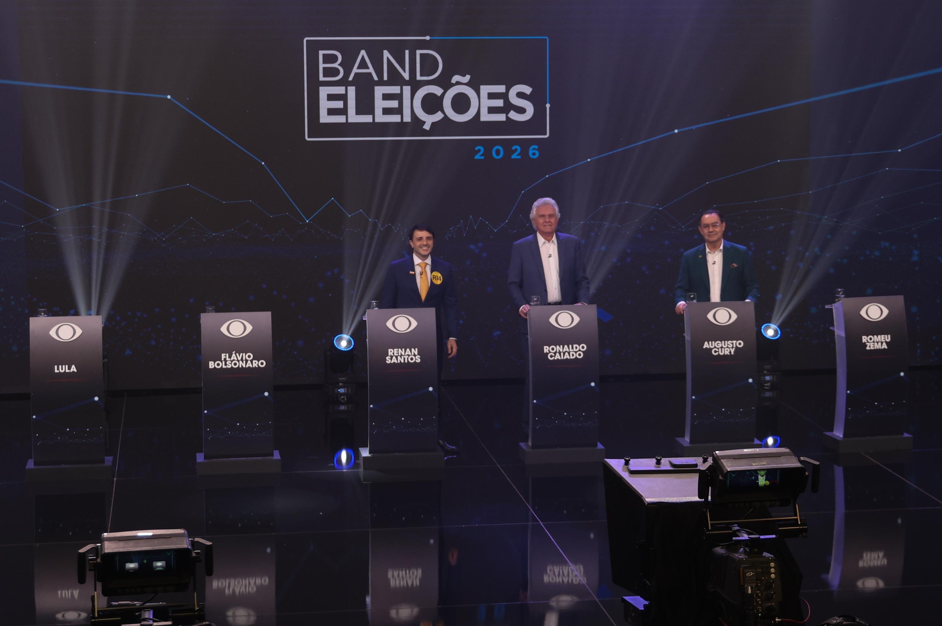 Renan Santos, Ronaldo Caiado e Augusto Cury durante debate, com as aus&ecirc;ncias de Lula, Fl&aacute;vio Bolsonaro e Romeu Zema