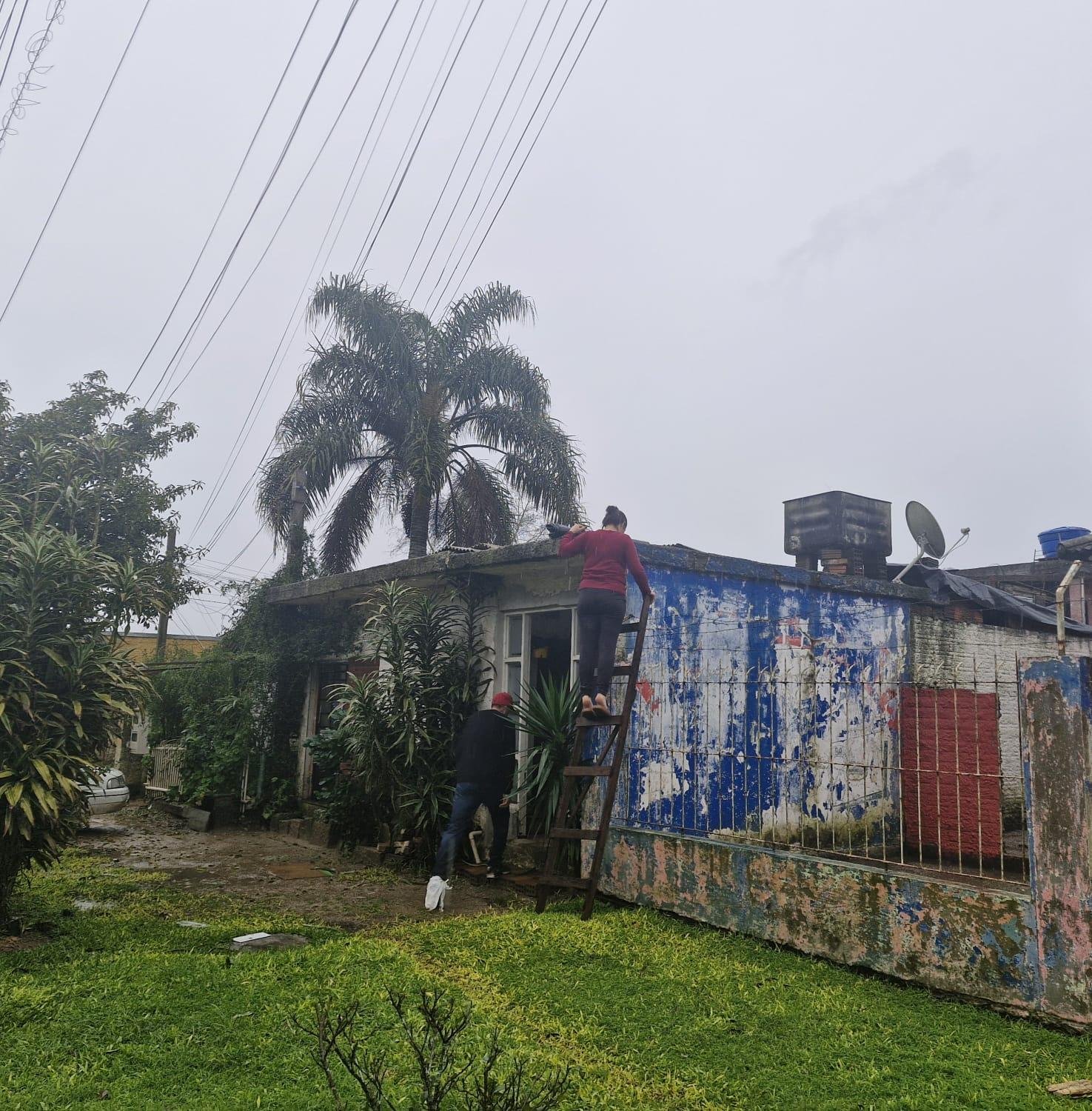 Camareira Tais Sousa Jardim enfrentou a chuva para colocar lona no telhado atingido pelo granizo