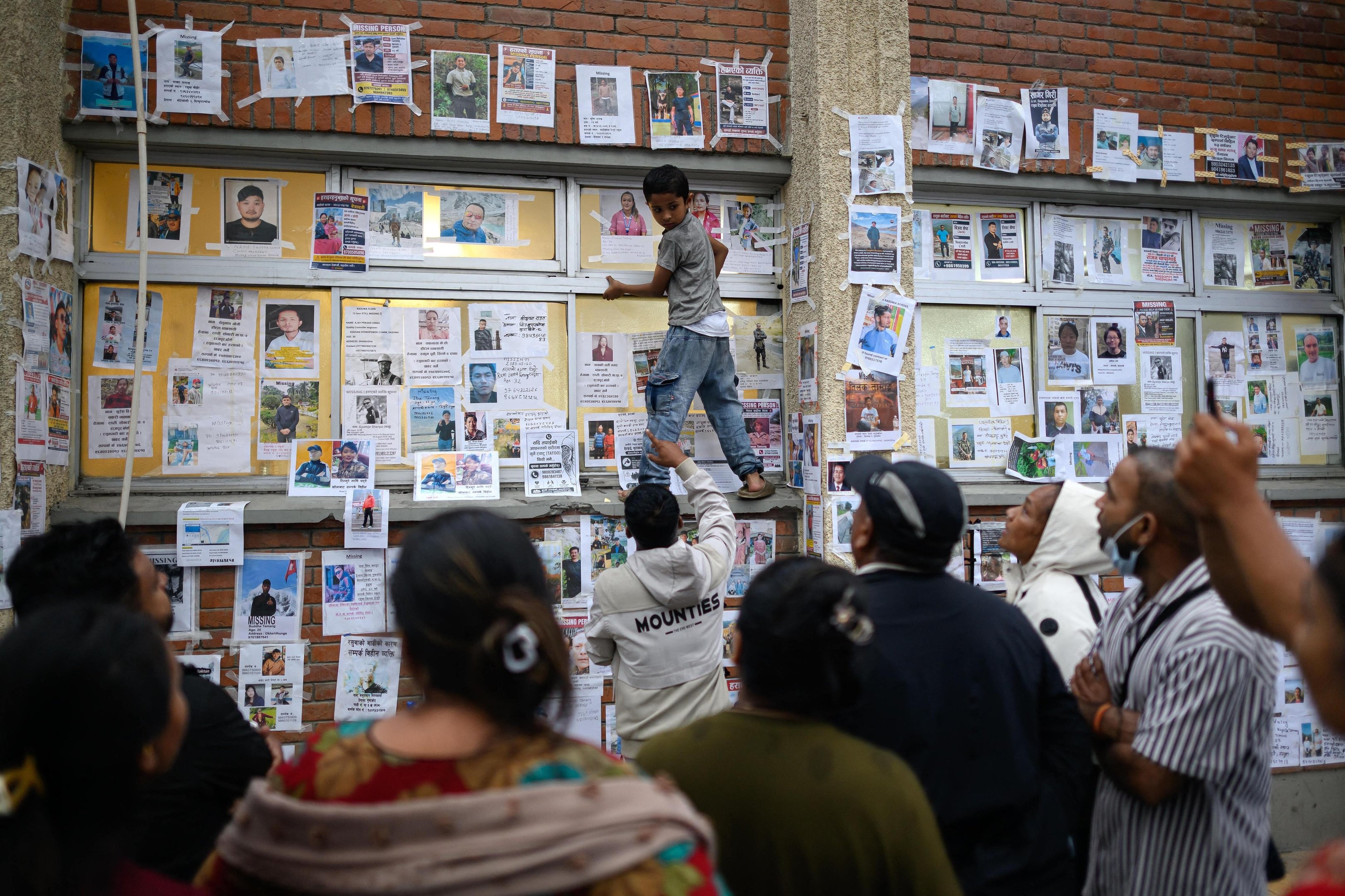 No hospital universit&aacute;rio da Universidade Tribhuvan, imagens de nepaleses e estrangeiros de todas as idades cobrem um muro de 25 metros e at&eacute; as colunas do lado de fora