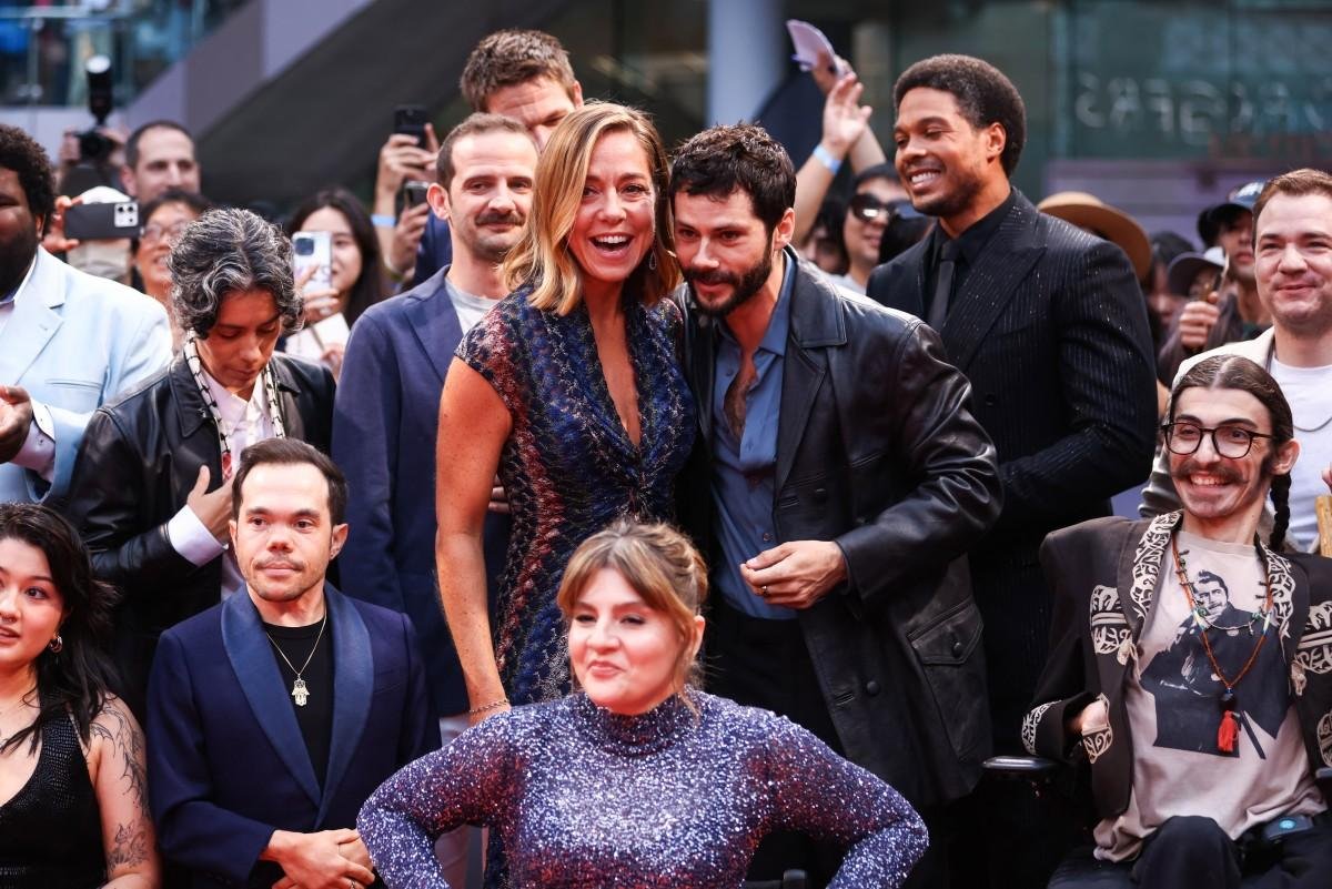 A cineasta americana Sian Heder e o ator americano Dylan O'Brien posam com o elenco e a equipe durante a estreia de "Being Heumann"