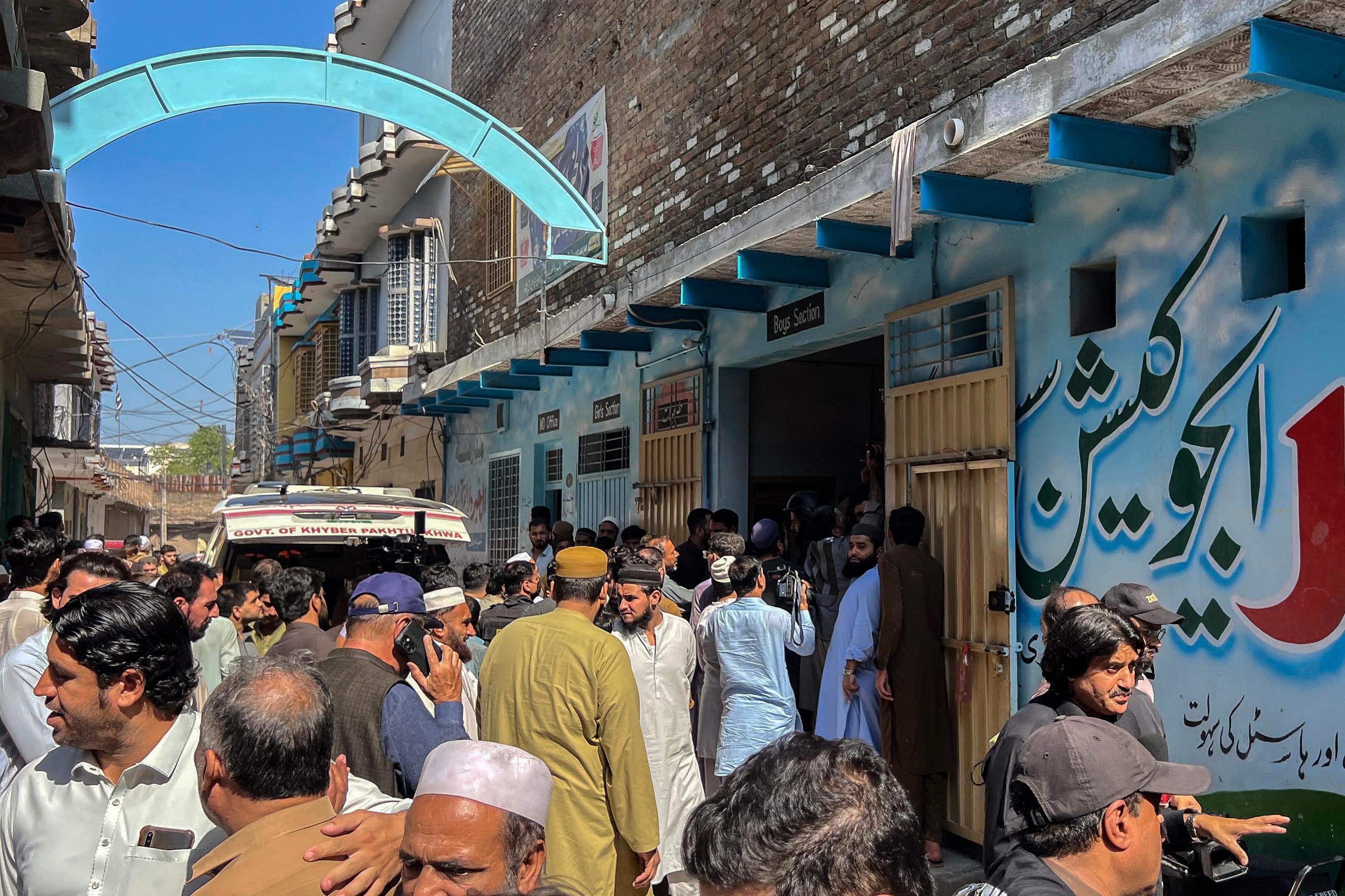 Moradores se re&uacute;nem durante uma opera&ccedil;&atilde;o de busca ap&oacute;s o desabamento do teto de uma escola em Peshawar