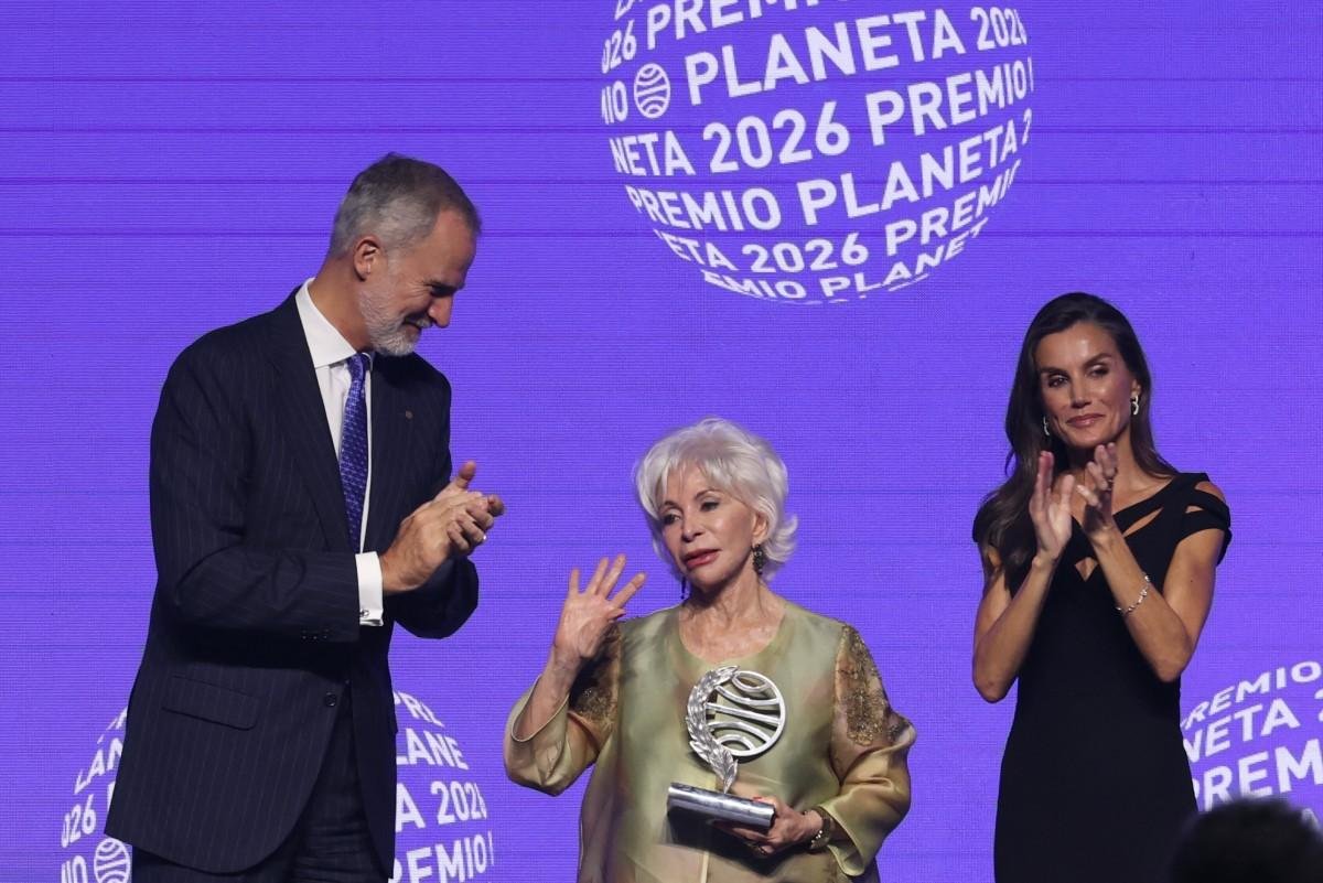 Vencedora do Pr&ecirc;mio Planeta da Espanha em 2026, a escritora chilena Isabel Allende (ao centro) acena ap&oacute;s receber o trof&eacute;u das m&atilde;os do rei Felipe VI (&agrave; esquerda) e da rainha Letizia, da Espanha, durante a cerim&ocirc;nia da 75&ordf; edi&ccedil;&atilde;o do Pr&ecirc;mio Planeta
