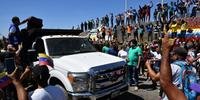 Pessoas comemoram enquanto caminhões com ajuda humanitária para a Venezuela se aproximam da fronteira Brasil-Venezuela em Pacaraima, em Roraima