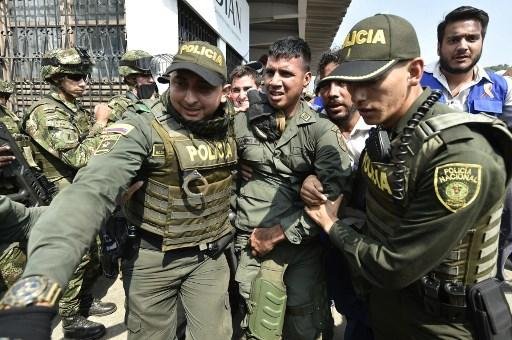 Policiais colombianos acompanham policial venezuelano que desertou da Venezuela na ponte internacional Simon Bolivar, em C&uacute;cuta,