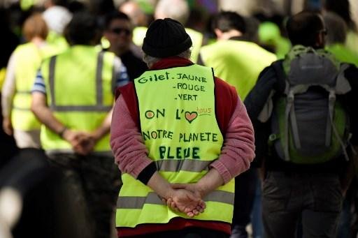 "Colete amarelo, vermelho ou verde, todos amamos nosso planeta azul", &eacute; o que diz no colete deste manifestante