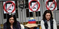 Ativistas venezuelanos protestam do lado de fora da embaixada do país em Washington