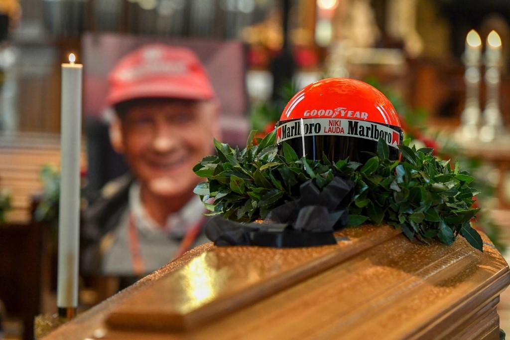 O capacete vermelho de Lauda foi depositado sobre o caix&atilde;o e milhares de pessoas fizeram fila sob forte chuva para poder prestar uma &uacute;ltima homenagem