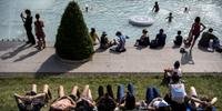 Com ondas de calor mais fortes, europeus descansam perto de uma lagoa, em Paris