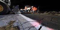 Homens trabalham em rodovia que registrou grandes estragos no Sul da Califórnia