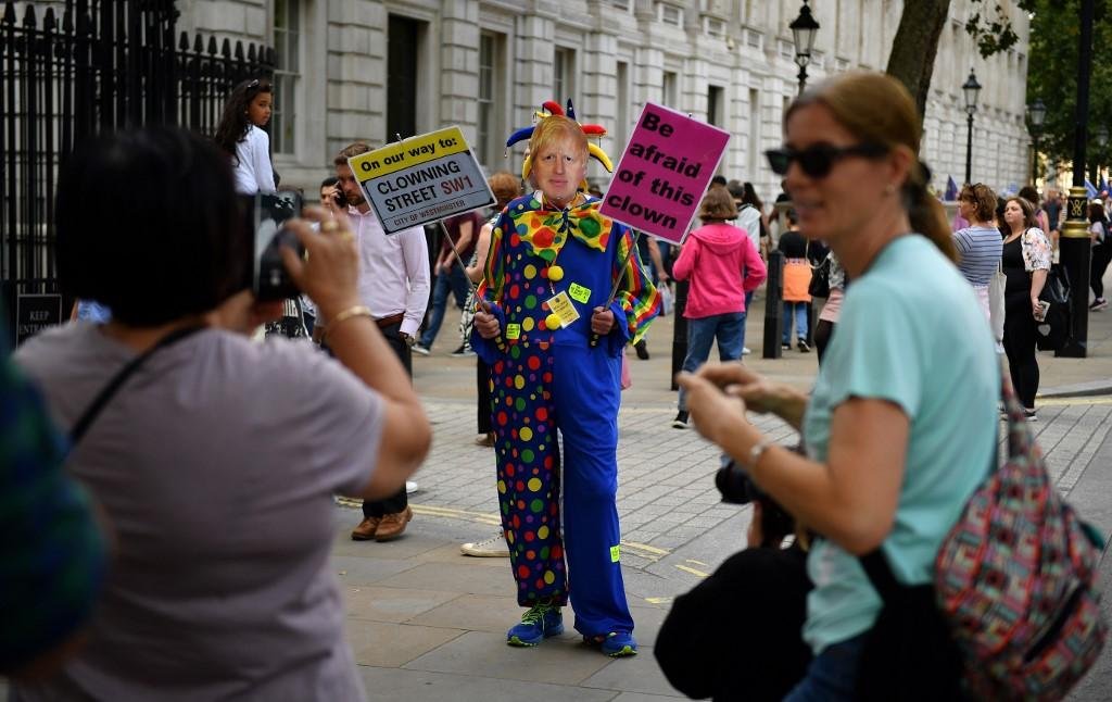 Turistas fazem fotos de palha&ccedil;o utilizando m&aacute;scara do premi&ecirc; Boris Johnson