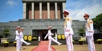 Velar Ho Chi Minh é o maior ato patriótico para estes homens vestidos com uniforme branco imaculado, que permanecem nas proximidades do santuário, um imponente edifício em Hanói